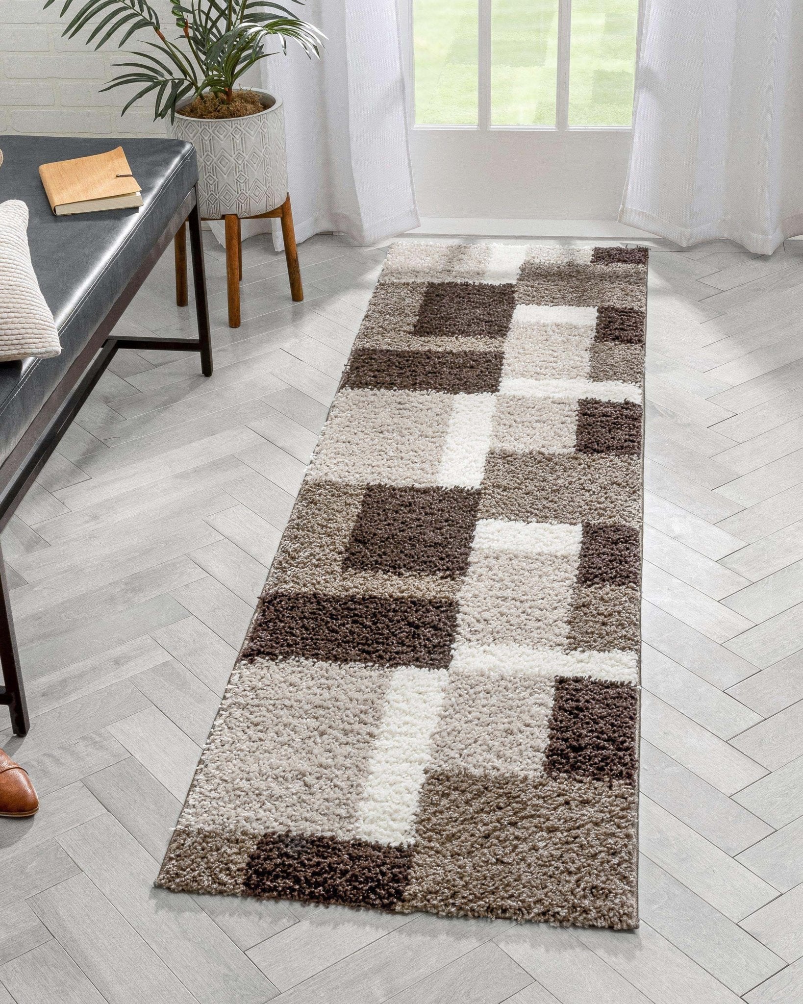 Cubes Beige Brown Modern Geo Rug - Well Woven - A long rectangular shag runner rug with a checkered block pattern in brown, beige, and ivory tones, styled in a bright hallway with herringbone tile flooring.