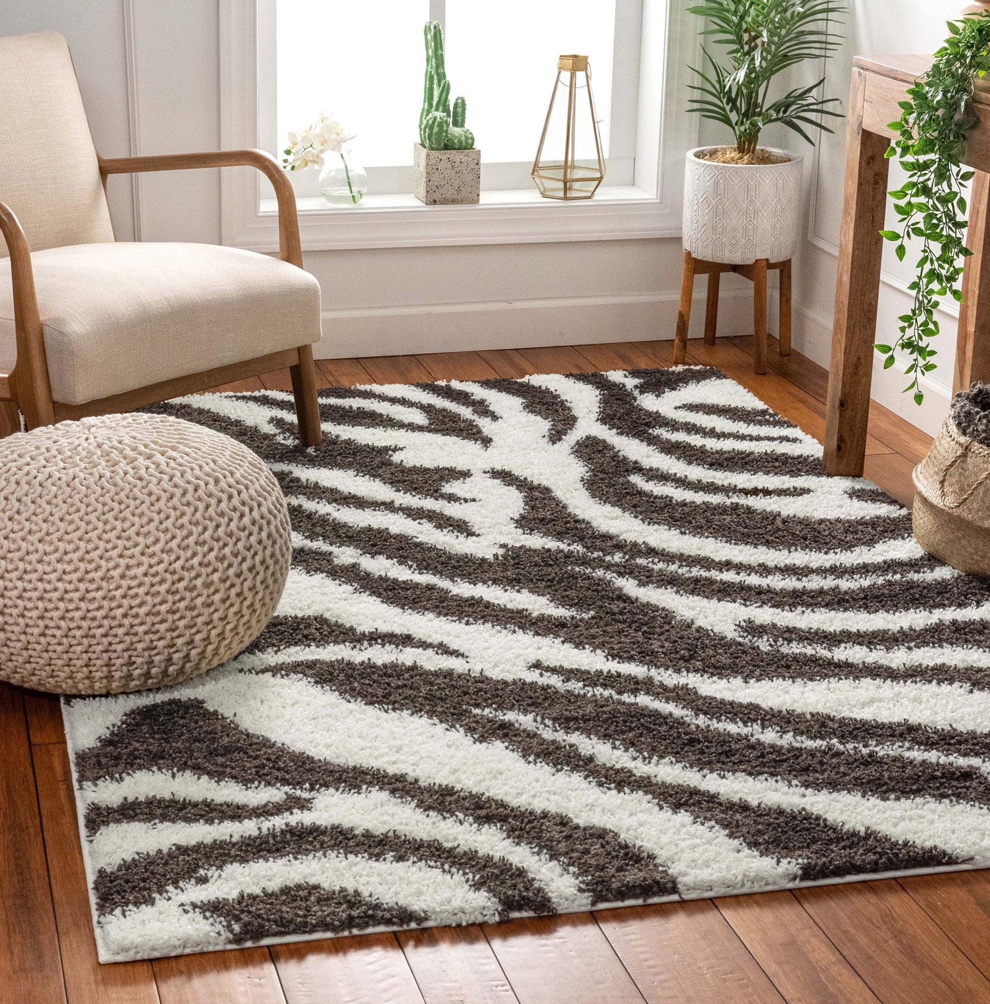 Safari Zebra Brown Contemporary Shag Rug - Well Woven - The brown zebra shag rug partially under a light armchair, showing depth and pile.