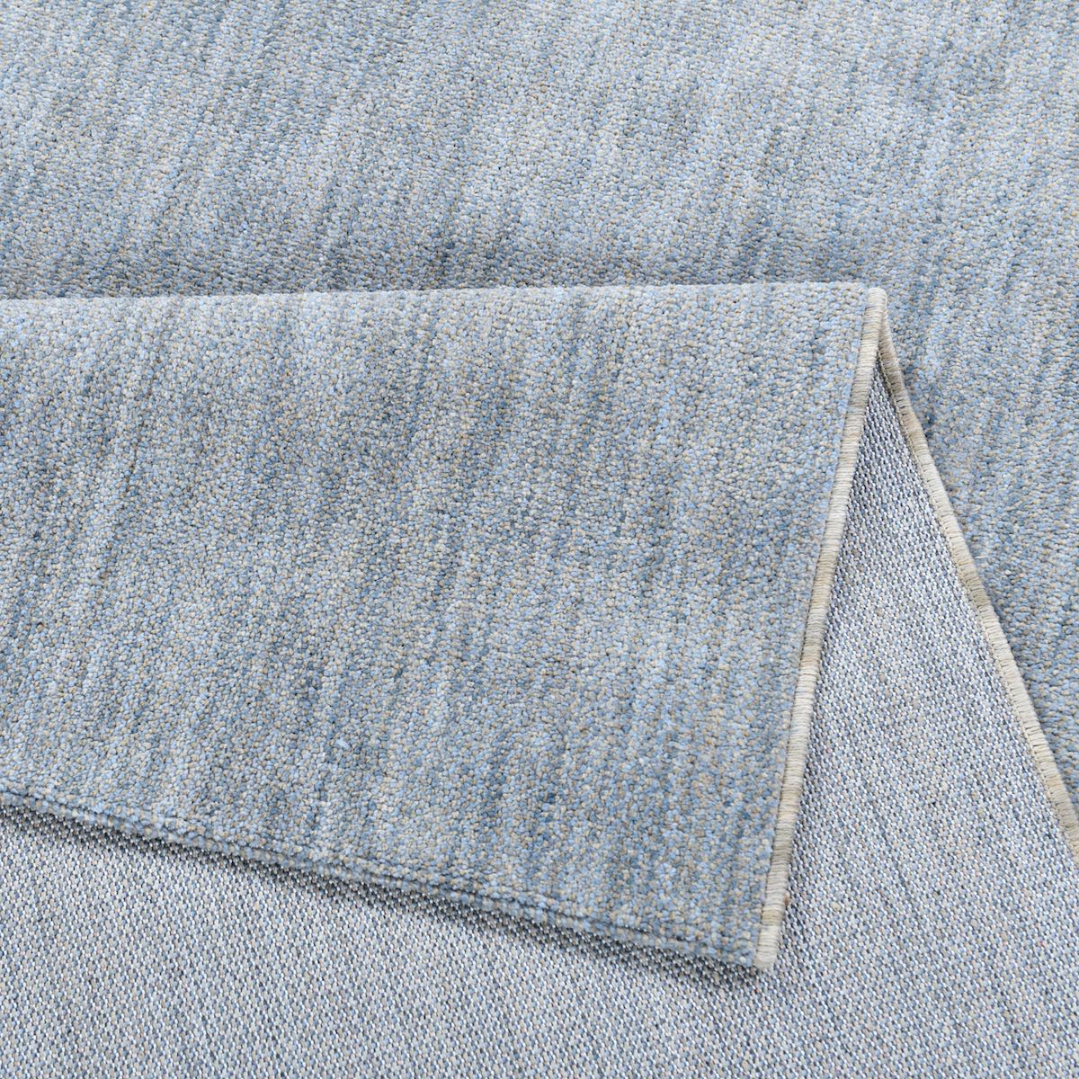 COD-17 Well Woven Moor Washable Rug: Close-up of a plush blue washable rug with a folded corner.