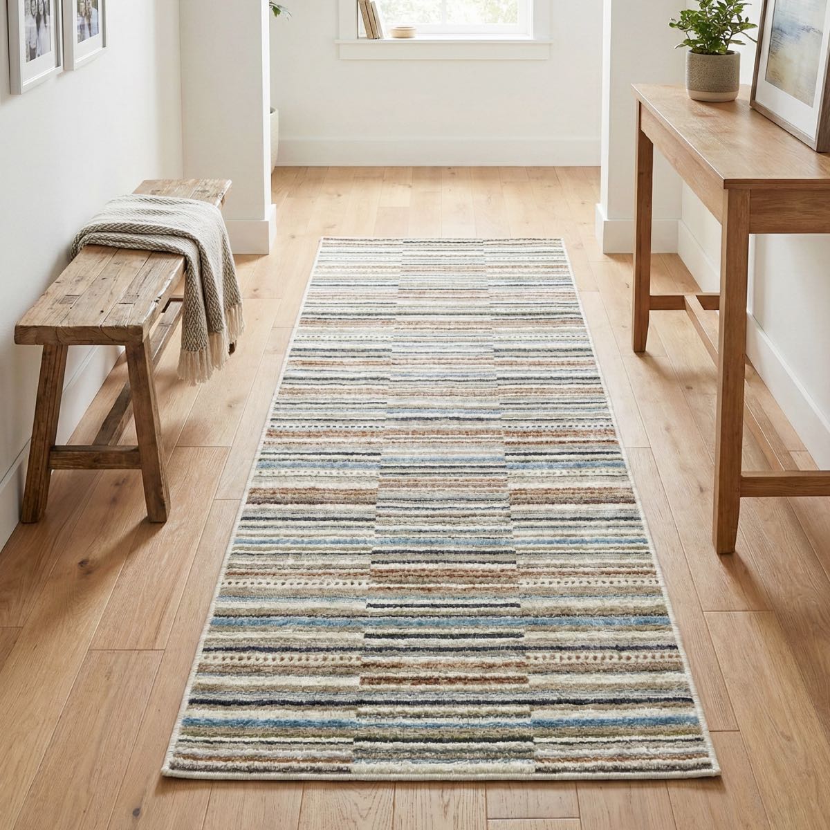 COD-41 - Multicolor striped runner rug on a wooden floor with a wooden bench and table in a room.