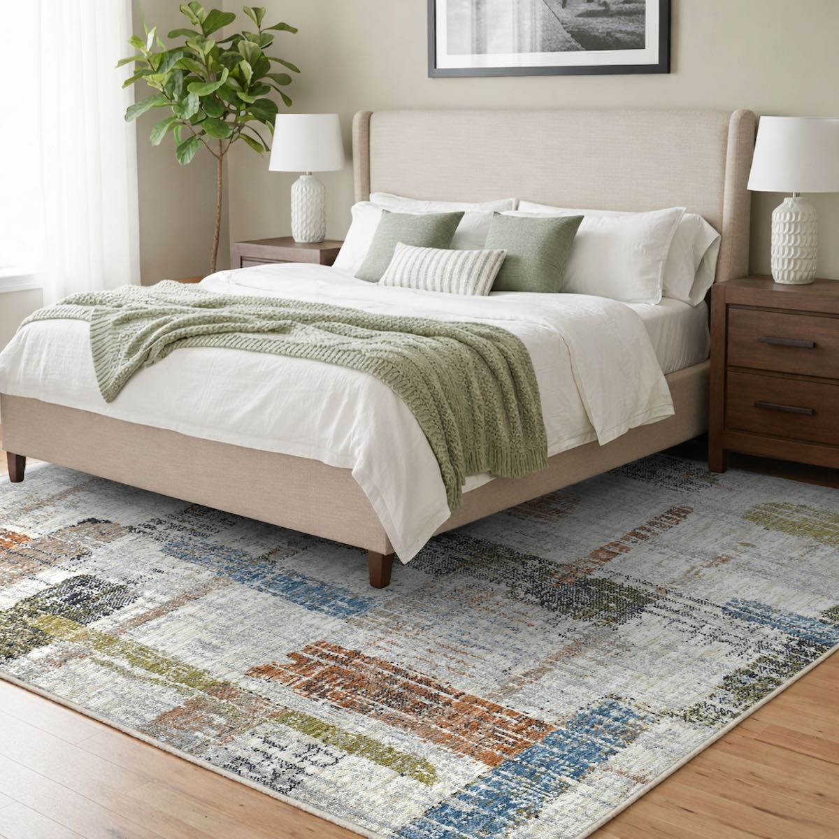 COD-51 Well Woven Fen Washable Rug - Neatly made bed with white bedding and green throw blanket in a bedroom setting. A multicolor abstract washable rug with pile made from recycled polyester anchors the space.