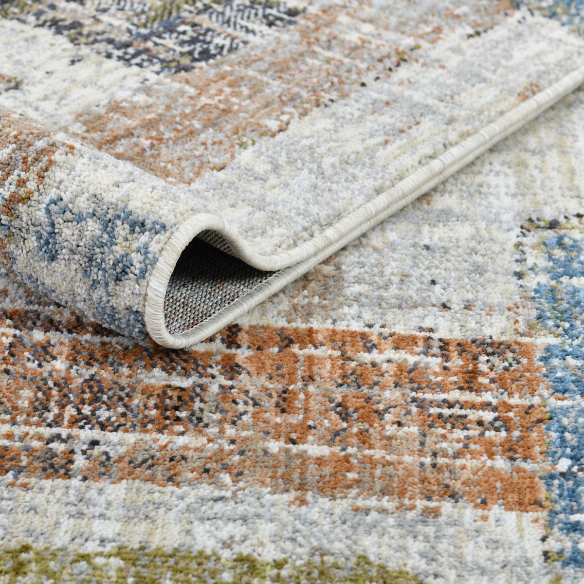 The COD-51 Well Woven Fen Washable Rug folded over itself, showing its soft rug texture and vibrant colors.