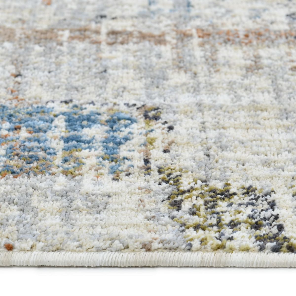 COD-51 Well Woven Fen Washable Rug: Close-up of a textured washable area rug with an abstract pattern in neutral colors, blue, red, green and charcoal