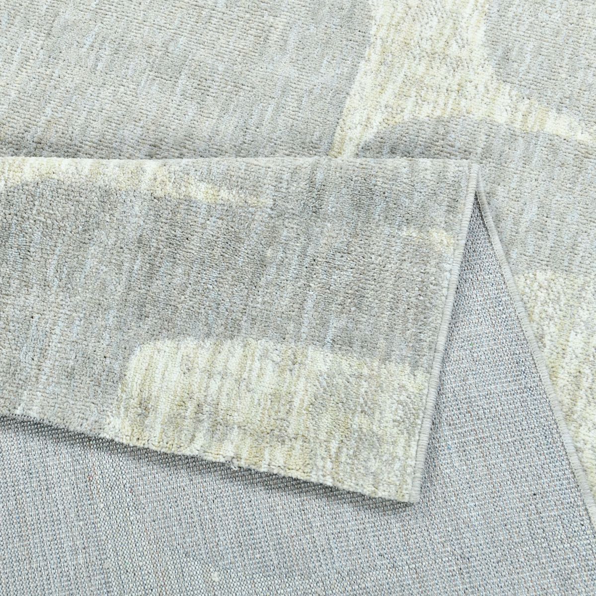 COD-72 Well Woven Wold Washable Rug: Close-up of the gray washable rug with a folded section showing its gentle back, safe for wood and tile floors