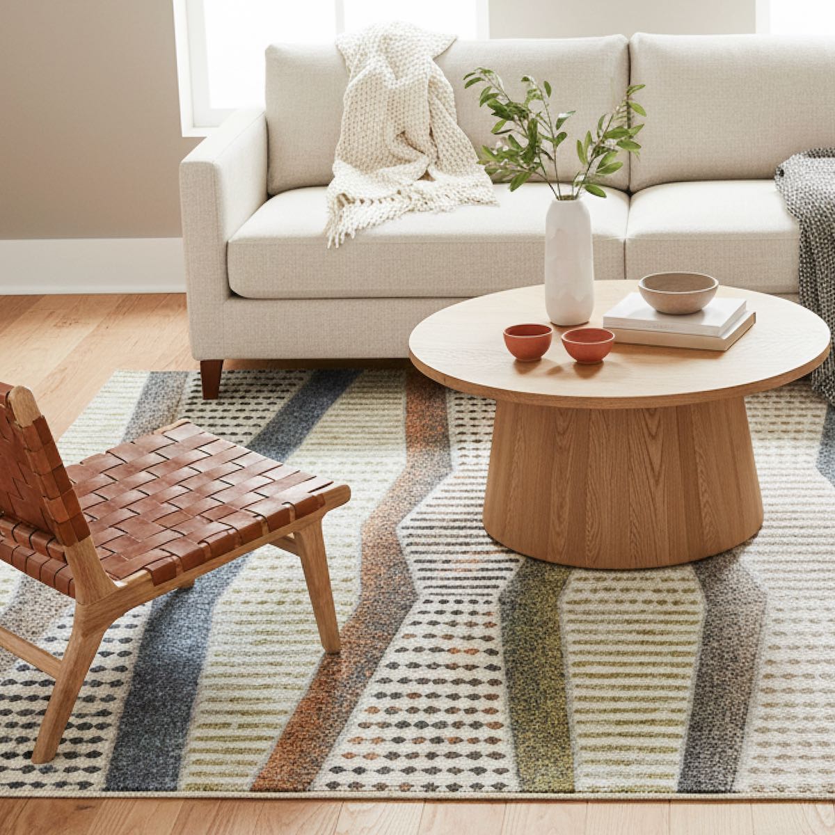 ELM-21 Well Woven Ridge Washable Area Rug: Living room with a beige sofa, wooden coffee table, and modern geometric rug anchoring the space.