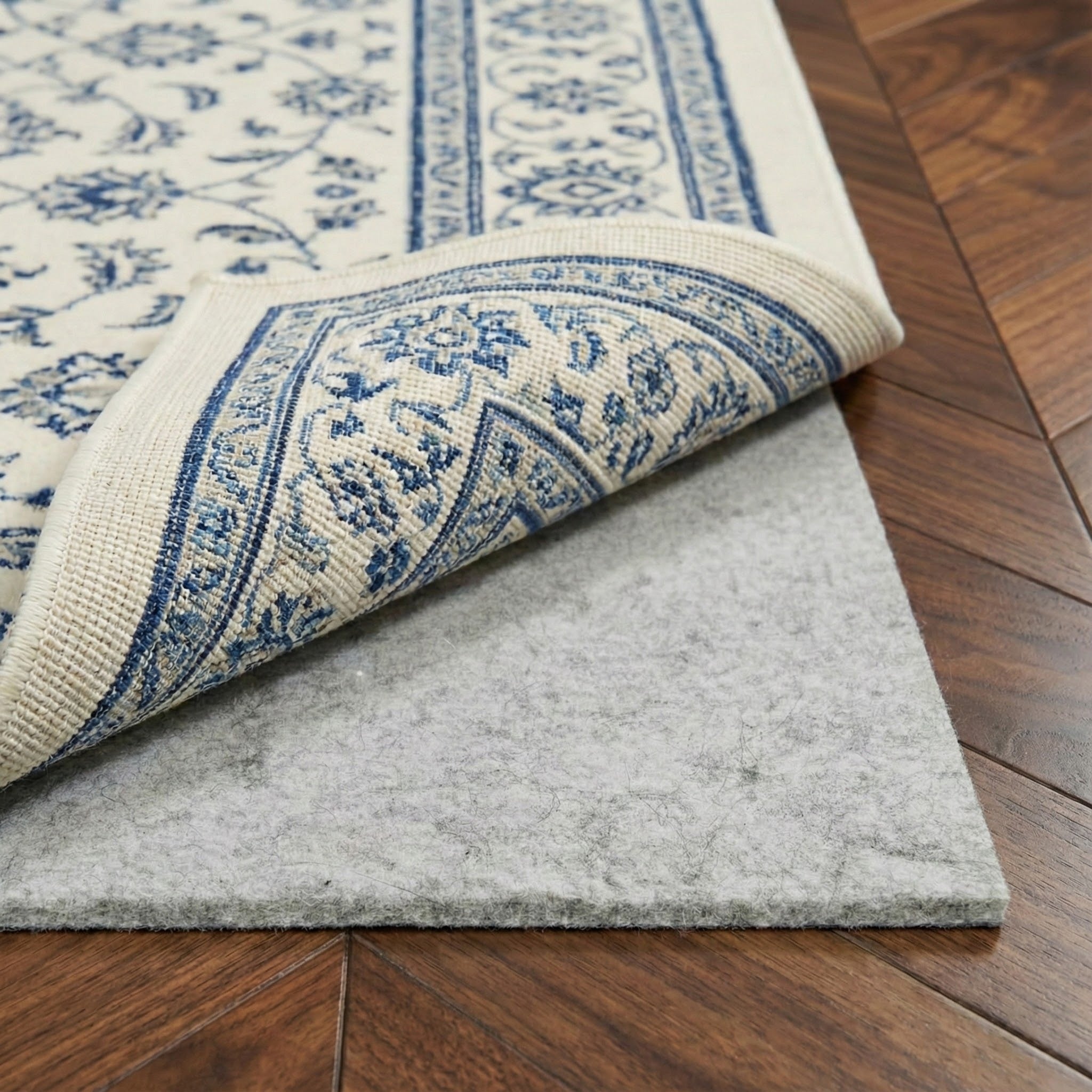 PAD-1 Blue and white patterned rug on a gray non-slip custom size rug pad underlay over a wooden floor