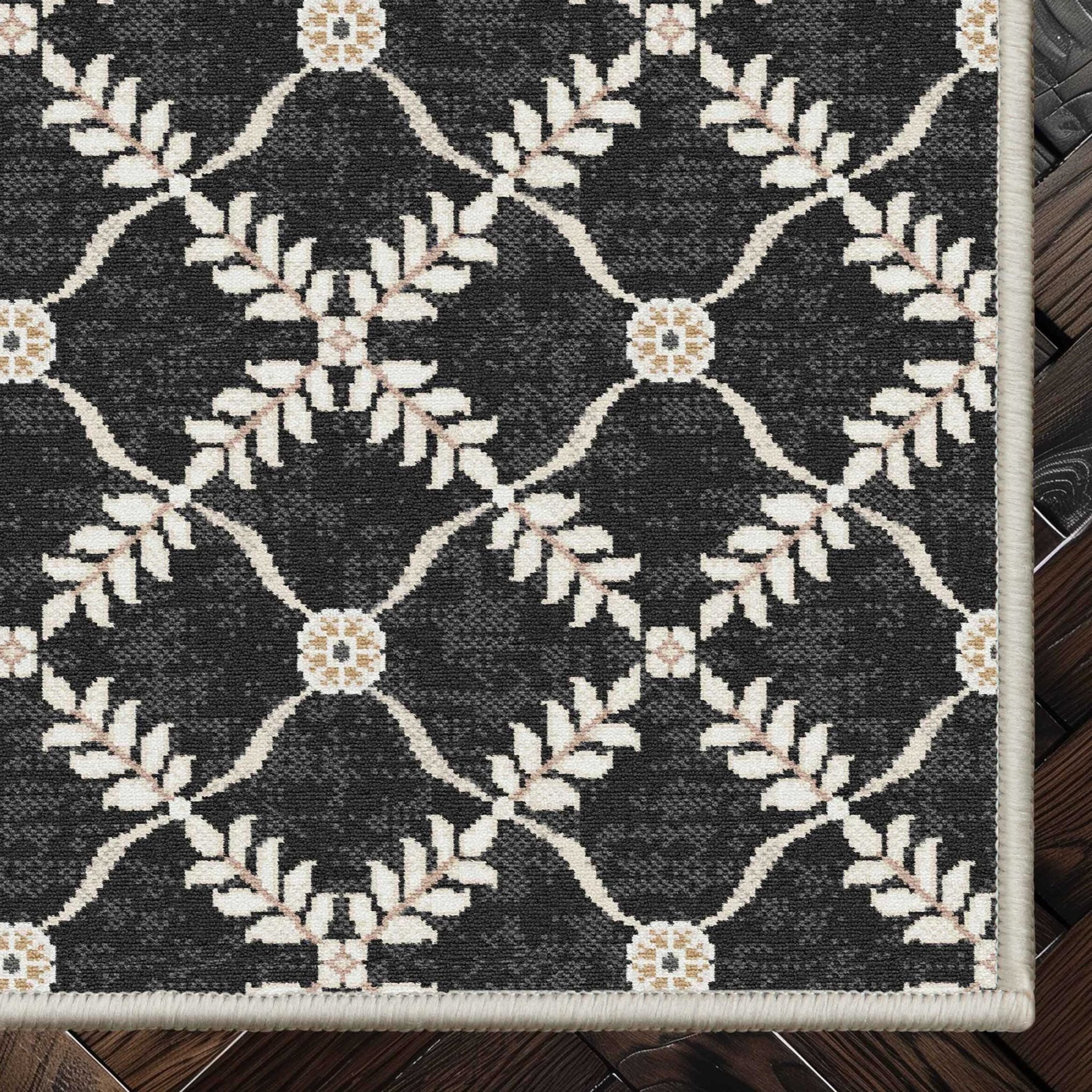 Well Woven - Aldwyn Black Custom Rug - rug corner on a dark wood floor