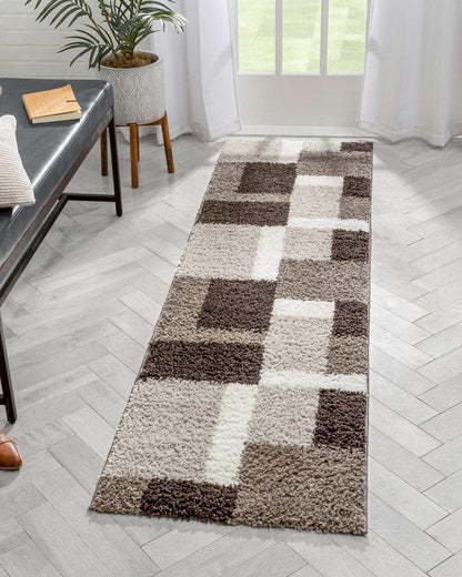 Cubes Beige Brown Modern Geo Rug - Well Woven - A long rectangular shag runner rug with a checkered block pattern in brown, beige, and ivory tones, styled in a bright hallway with herringbone tile flooring.