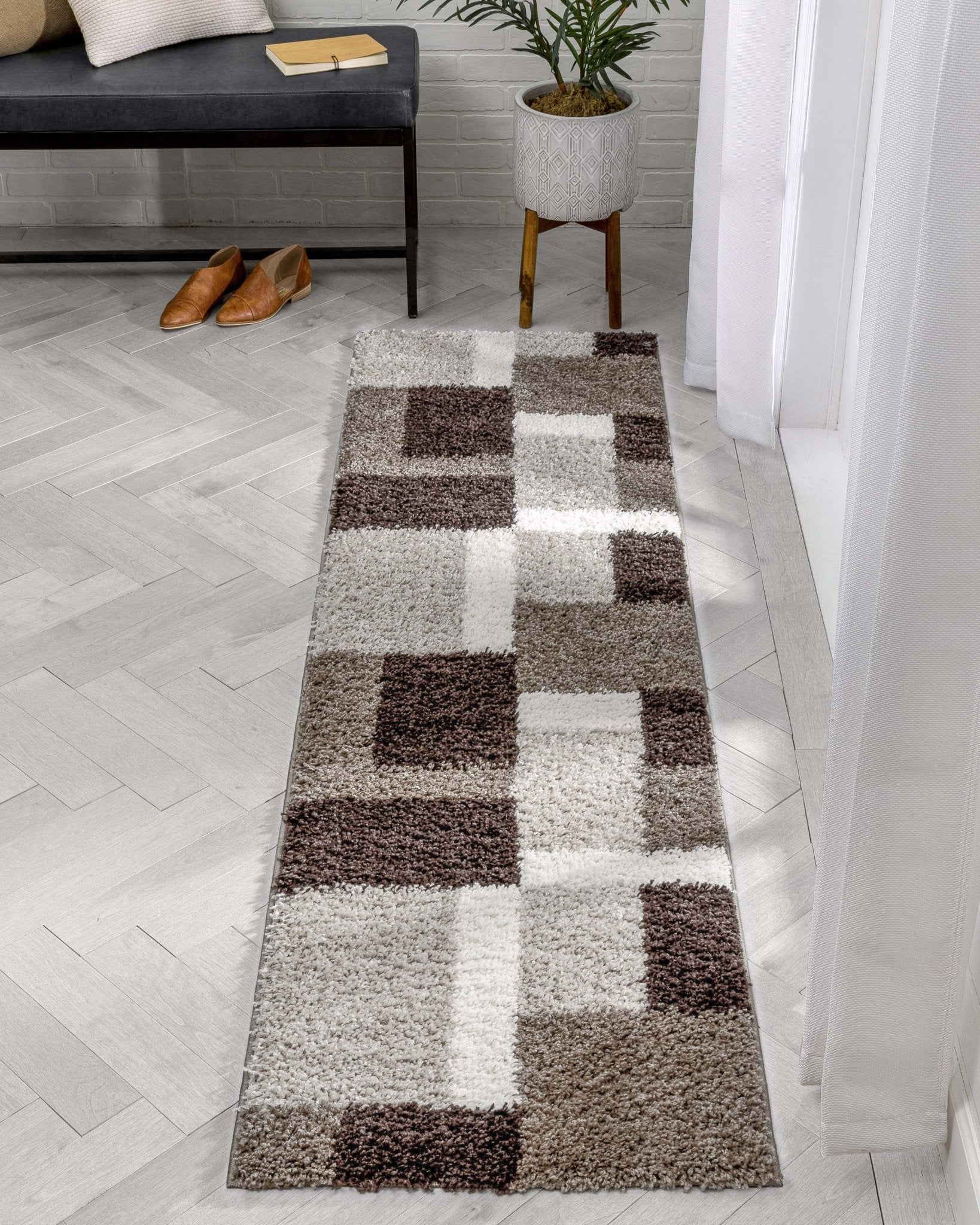 Cubes Beige Brown Modern Geo Rug - Well Woven - A soft shag runner rug displayed at an angle in a hallway, showing its plush pile and soft neutral tones.