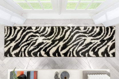 Safari Zebra Black Contemporary Shag Rug - Well Woven - Top-down view of the rug stretching across a hallway or entryway, showing the full graphic pattern.