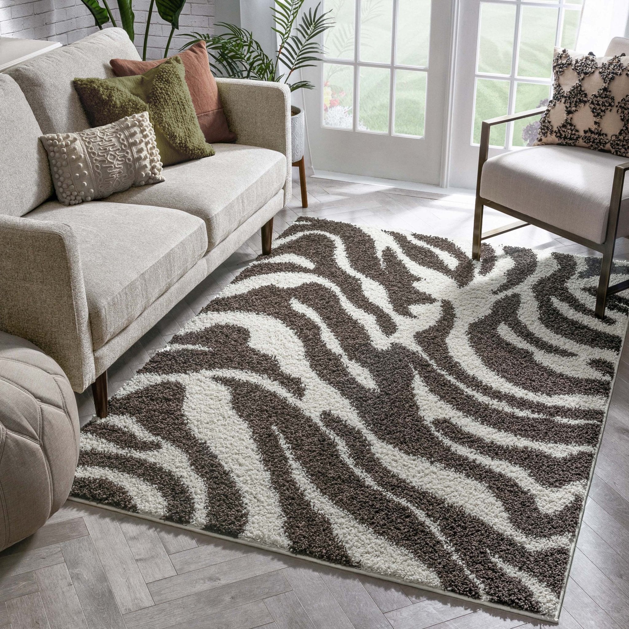 Safari Zebra Brown Contemporary Shag Rug - Well Woven - the zebra shag rug rug styled in a bright, inviting living room with beige sofas and large windows, adding a bold, organic feel to the space.