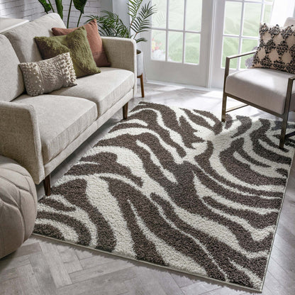 Safari Zebra Brown Contemporary Shag Rug - Well Woven - the zebra shag rug rug styled in a bright, inviting living room with beige sofas and large windows, adding a bold, organic feel to the space.