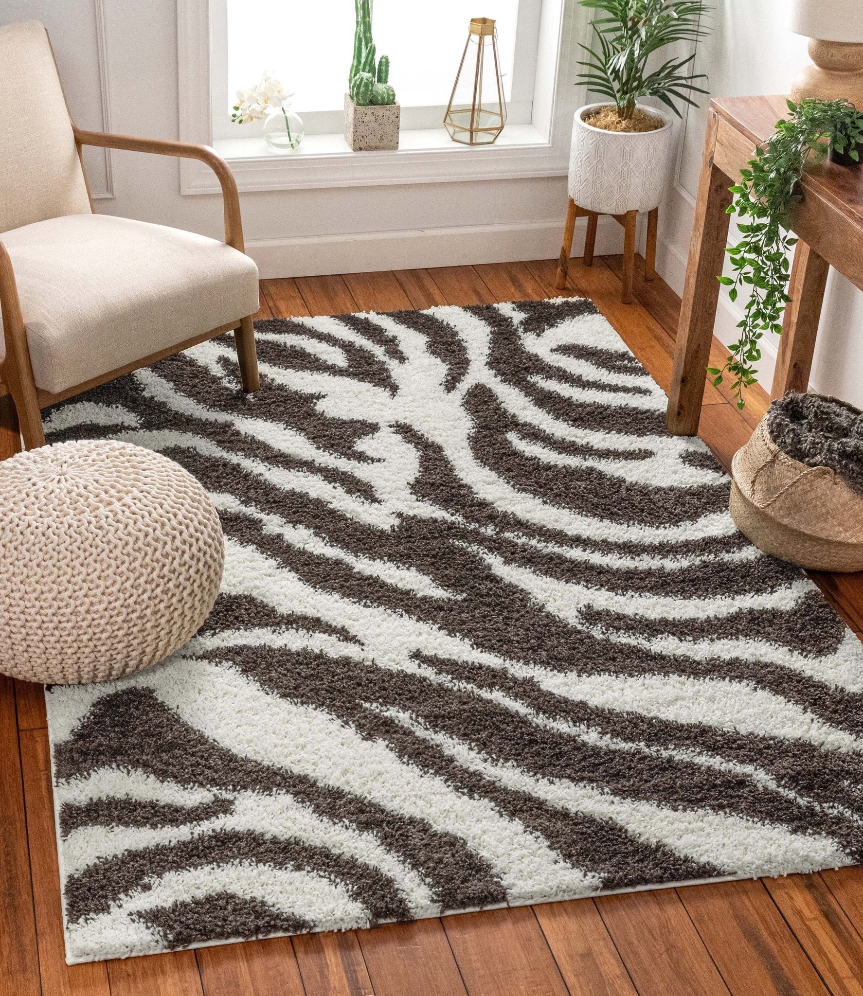 Safari Zebra Brown Contemporary Shag Rug - Well Woven - A bold brown and white zebra-print rug placed under a curved accent chair on hardwood floors with cozy, neutral decor.