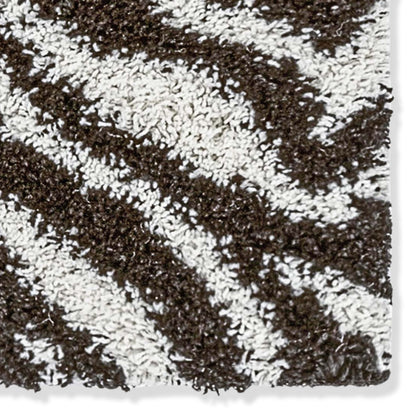 Close-up of a textured brown and white zebra patterned shag rug