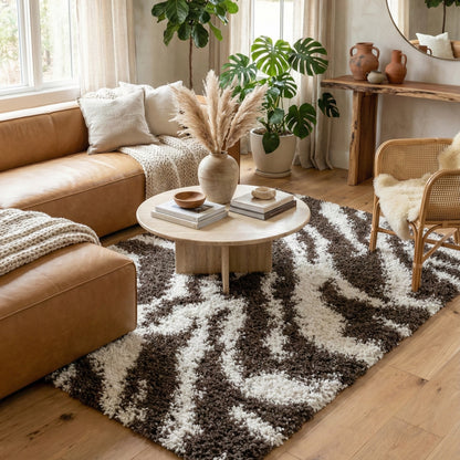 7038 - Living room with brown leather sofa, round wooden coffee table, and patterned rug with zebra stripes in brown and off white.