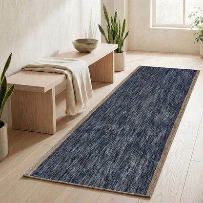 COD-13 - Long blue and brown runner rug on a wooden floor with a bench and plants in a room.