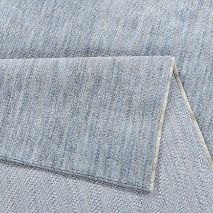 COD-17 Well Woven Moor Washable Rug: Close-up of a plush blue washable rug with a folded corner.