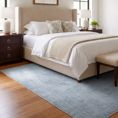 COD-17 Well Woven Moor Washable Rug - Neatly made bed in a bedroom with a soft blue washable area rug on the floor.