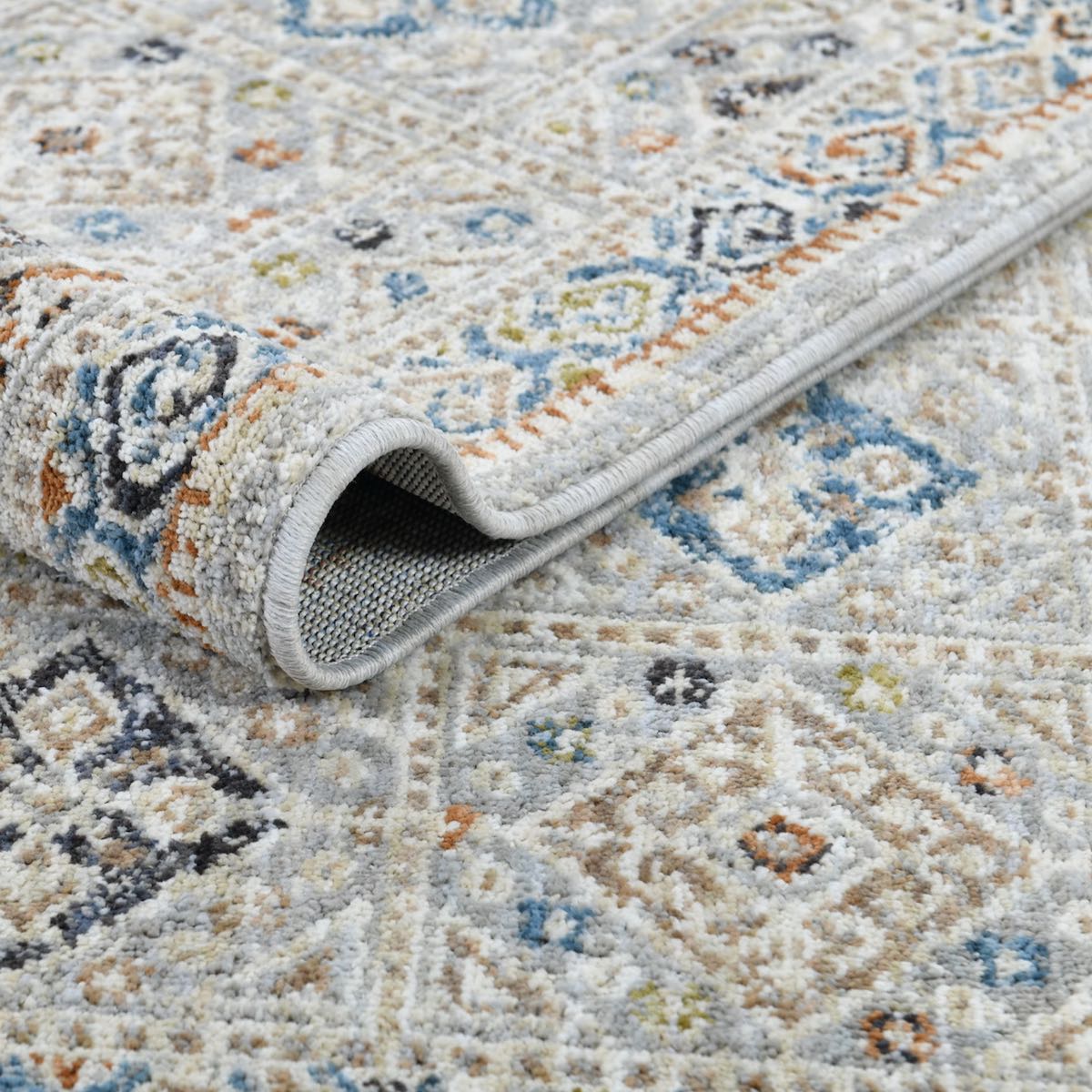 COD-21 Well Woven Mere Washable Rug: Patterned multicolor rug folded over itself, showing texture and design details.