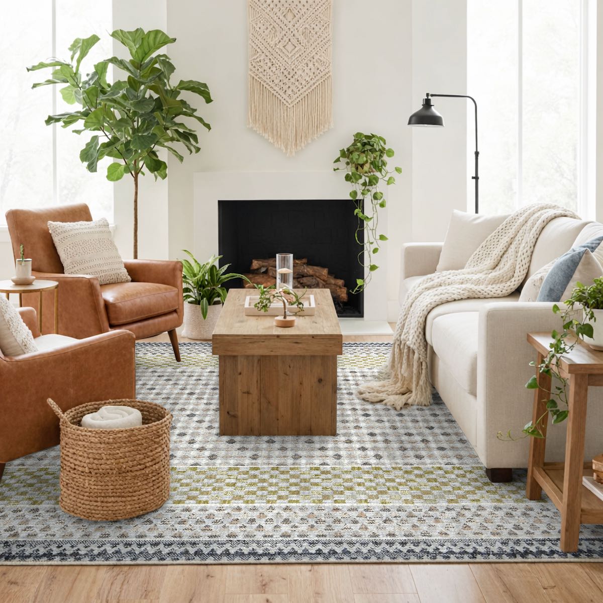 COD-31 Well Woven Wynn Washable Rug - Cozy living room with brown armchair, white sofa, wooden coffee table, and decorative plants. A grey and green geometric washable rug anchors the seating area.