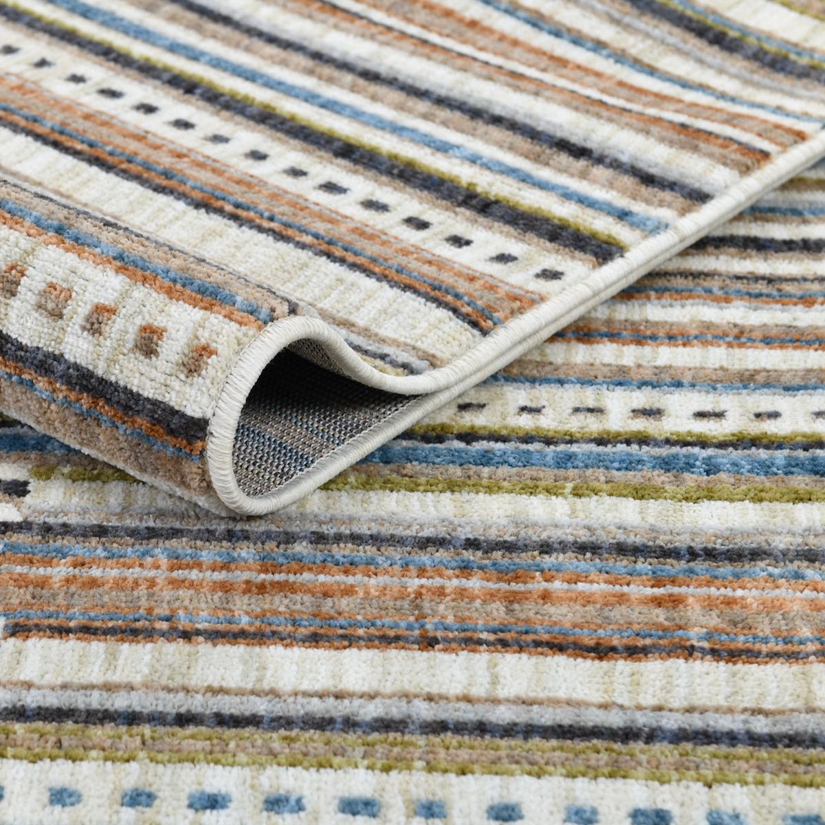 COD-41 Well Woven Thane Washable Rug: A close-up of the soft geometric rug's striped pattern in shades of cream, blue, green and terracotta