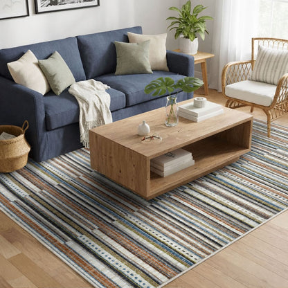 COD-41 Well Woven Thane Washable Rug - Modern living room with a blue sofa, wooden coffee table, and striped washable rug.