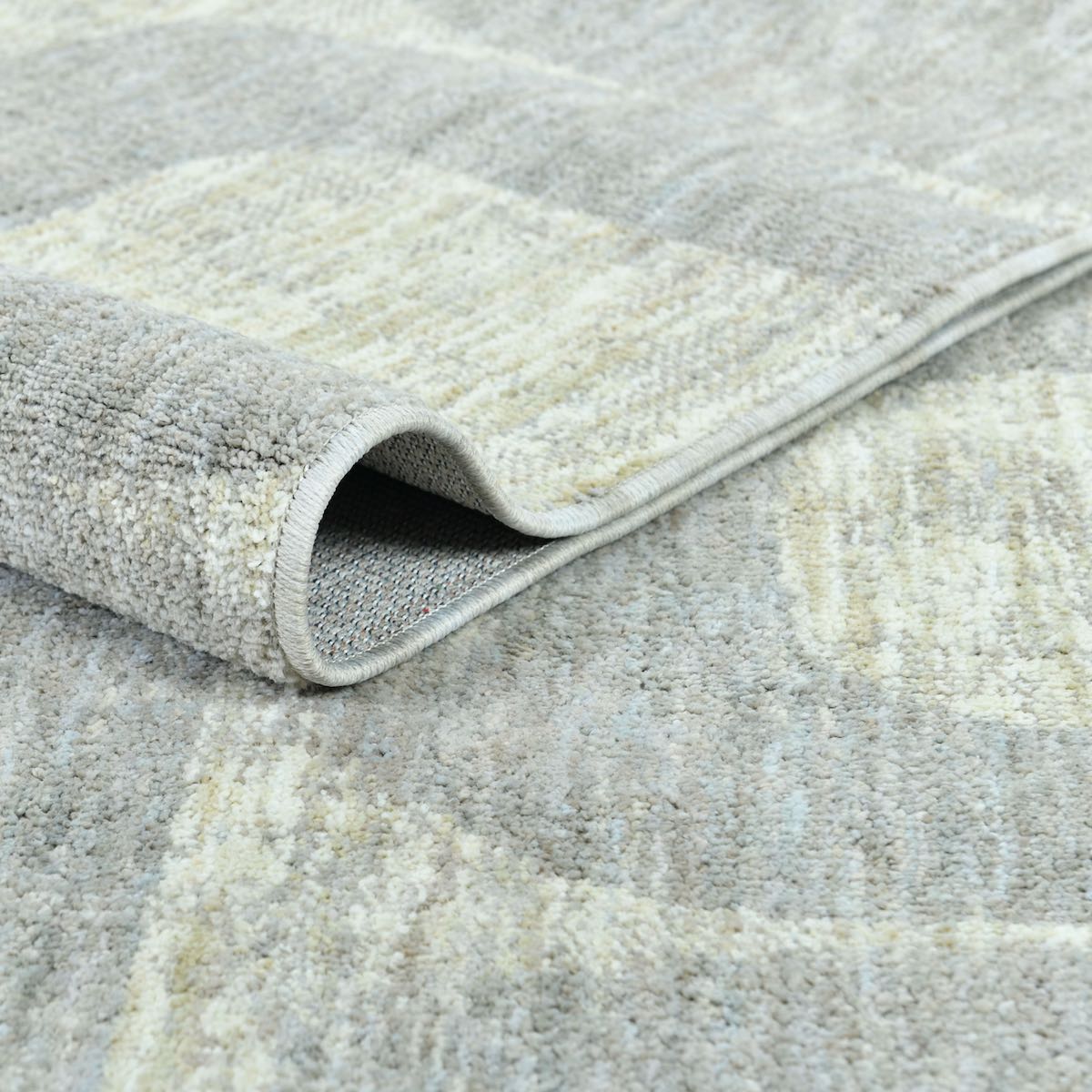COD-72 Well Woven Wold Washable Rug: Gray and cream patterned rug folded over itself to showcase its soft texture and recycled polyester pile