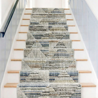 ELM-11-R - Staircase with a soft geometric runner rug in grey, blue and cream on wooden steps with white risers. Light blue board and batten lines the walls.