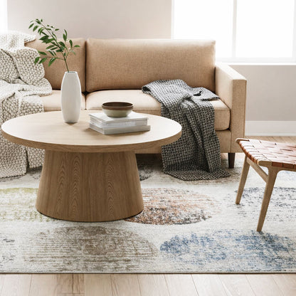 ELM-31 Well Woven Vale Washable Area Rug: Living room with beige sofa, wooden coffee table, and decorative items, like a washable rug.