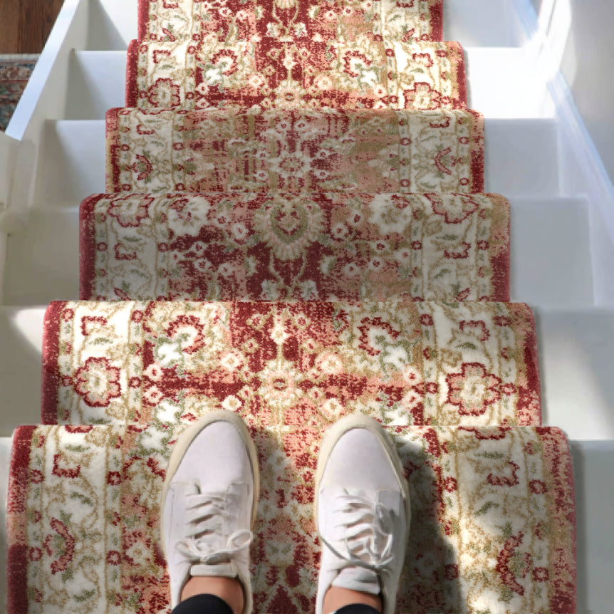 IND-100 Patterned red and beige stair runner on a staircase with white sneakers at the bottom.