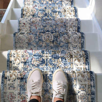 IND-106 Patterned blue and beige staircase runner rug with a person wearing white sneakers standing on it.