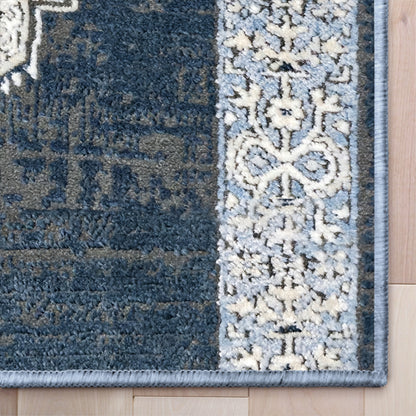 IND-163 Close-up of a blue and gray patterned rug on a wooden floor.