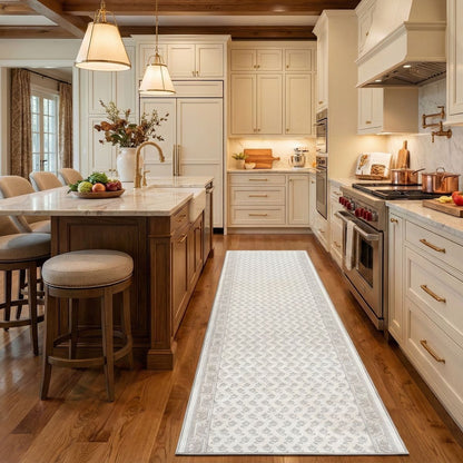 Off-white patterned kitchen runner rug on wood floor in a classic white kitchen. The white runner is Apollo Windsor Windsor Frosted Linen from Well Woven.