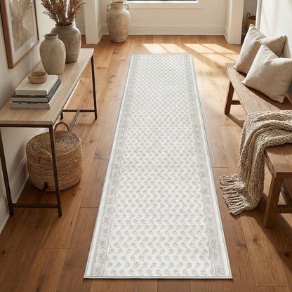 Off-white patterned hallway runner rug on light wood floor in a bright, neutral entryway. The white runner is Apollo Windsor Windsor Frosted Linen from Well Woven.
