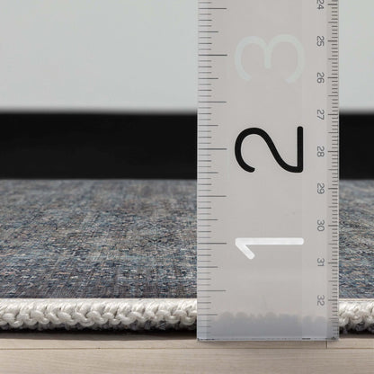 Close up profile of the Juliette Flatwoven Runner Rug with a ruler showing measurements on a wooden floor. 