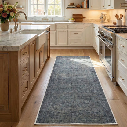 The Juliette Vintage Persian Blue Custom Runner Rug by Well Woven brings vintage elegance and comfort to a modern kitchen.