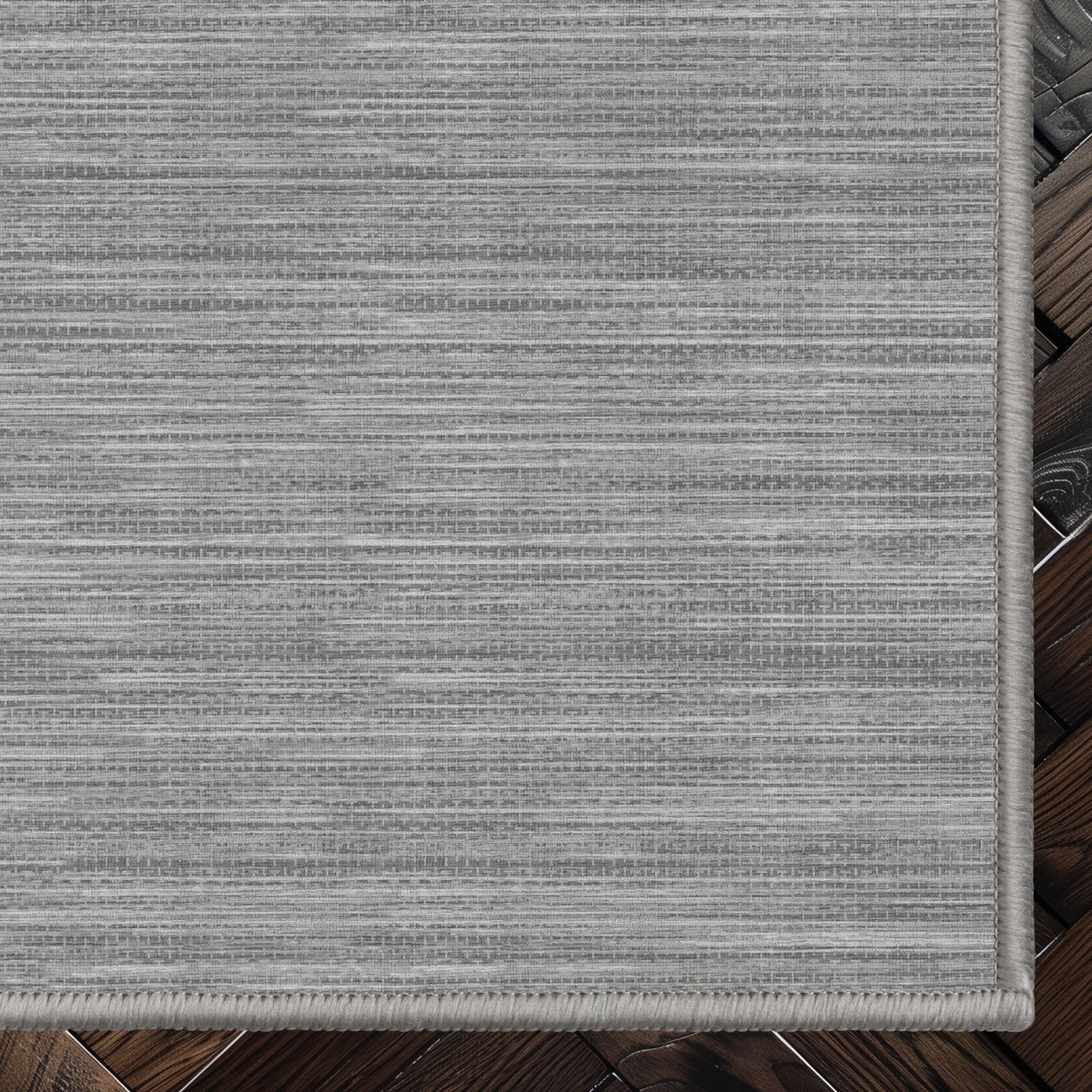 Edwin Custom Rug - Monochrome Striation , Flat Pile, Easy Clean, Customizable for Your Space - Well Woven - Top-down corner image showing the rug’s smooth, uniform weave and cool grey toned rug color.