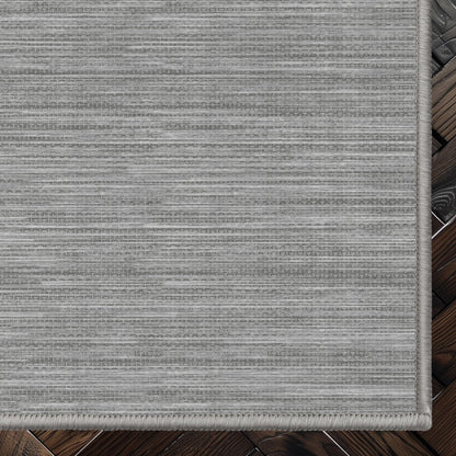 Edwin Custom Rug - Monochrome Striation , Flat Pile, Easy Clean, Customizable for Your Space - Well Woven - Top-down corner image showing the rug’s smooth, uniform weave and cool grey toned rug color.