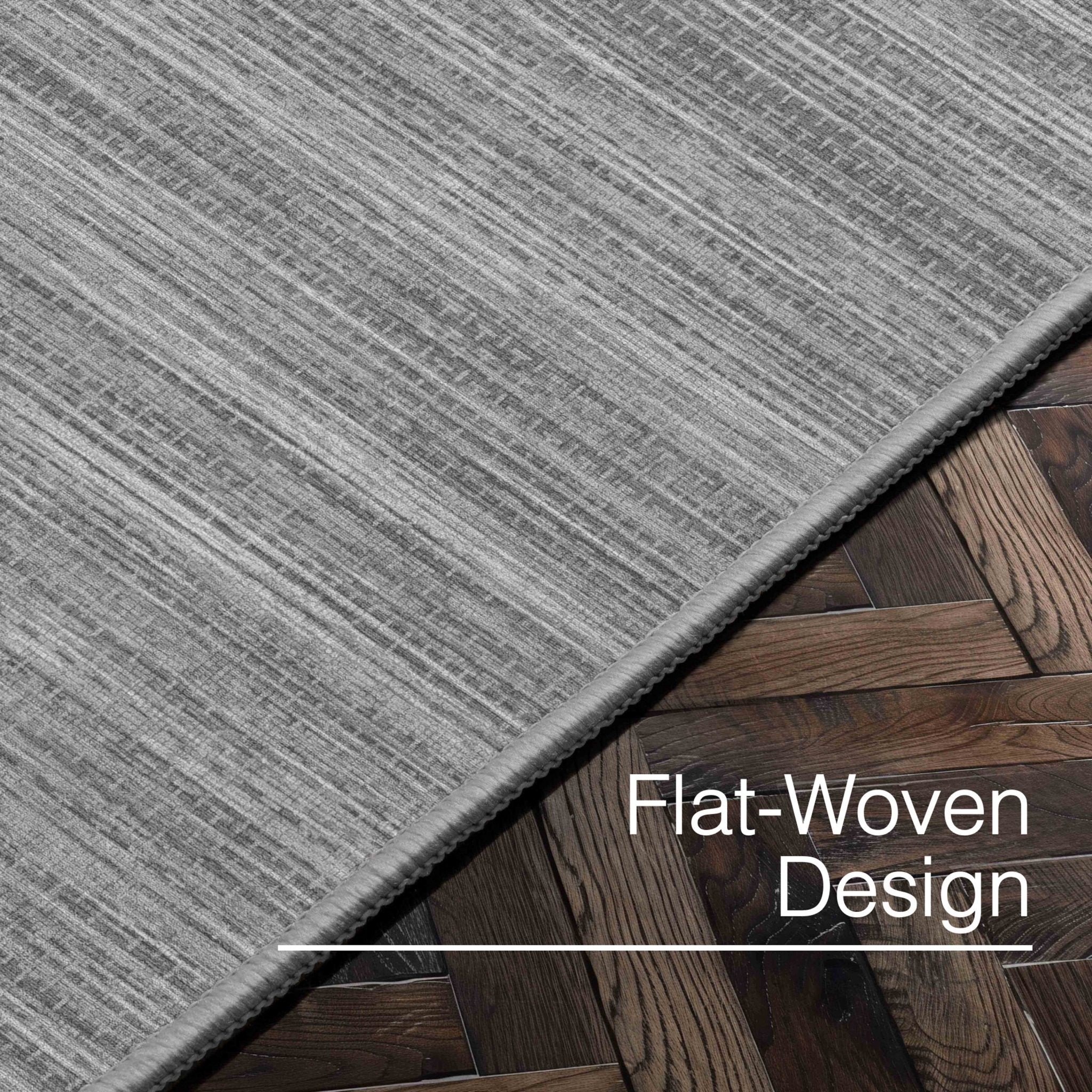 Edwin Custom Rug - Monochrome Striation , Flat Pile, Easy Clean, Customizable for Your Space - Well Woven - Angled close-up of the gray rug with text: “Flat-Woven Design.”