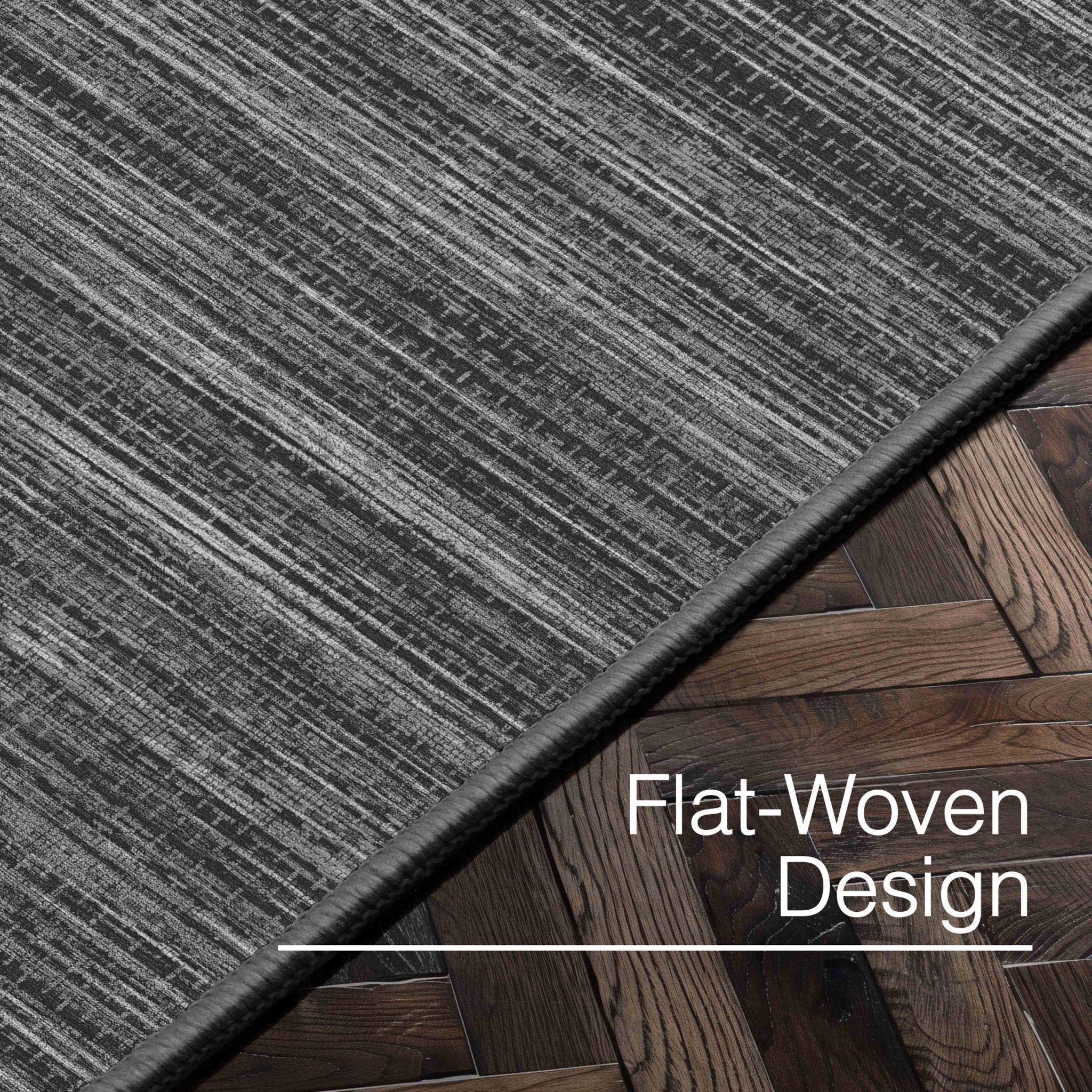 Edwin Custom Rug - Monochrome Striation , Flat Pile, Easy  Clean, Customizable for Your Space - Well Woven - Angled close-up of the dark grey rug with text: “Flat-Woven Design.”
