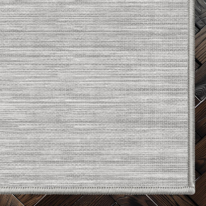 Edwin Custom Rug - Monochrome Striation , Flat Pile, Easy  Clean, Customizable for Your Space - Well Woven - Top-down corner image showing the rug’s smooth, uniform weave and cool light grey toned rug color.