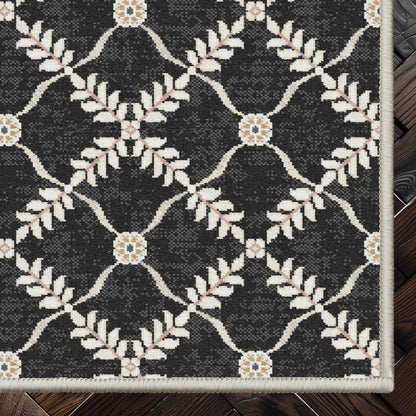 Well Woven - Aldwyn Black Custom Rug - rug corner on a dark wood floor