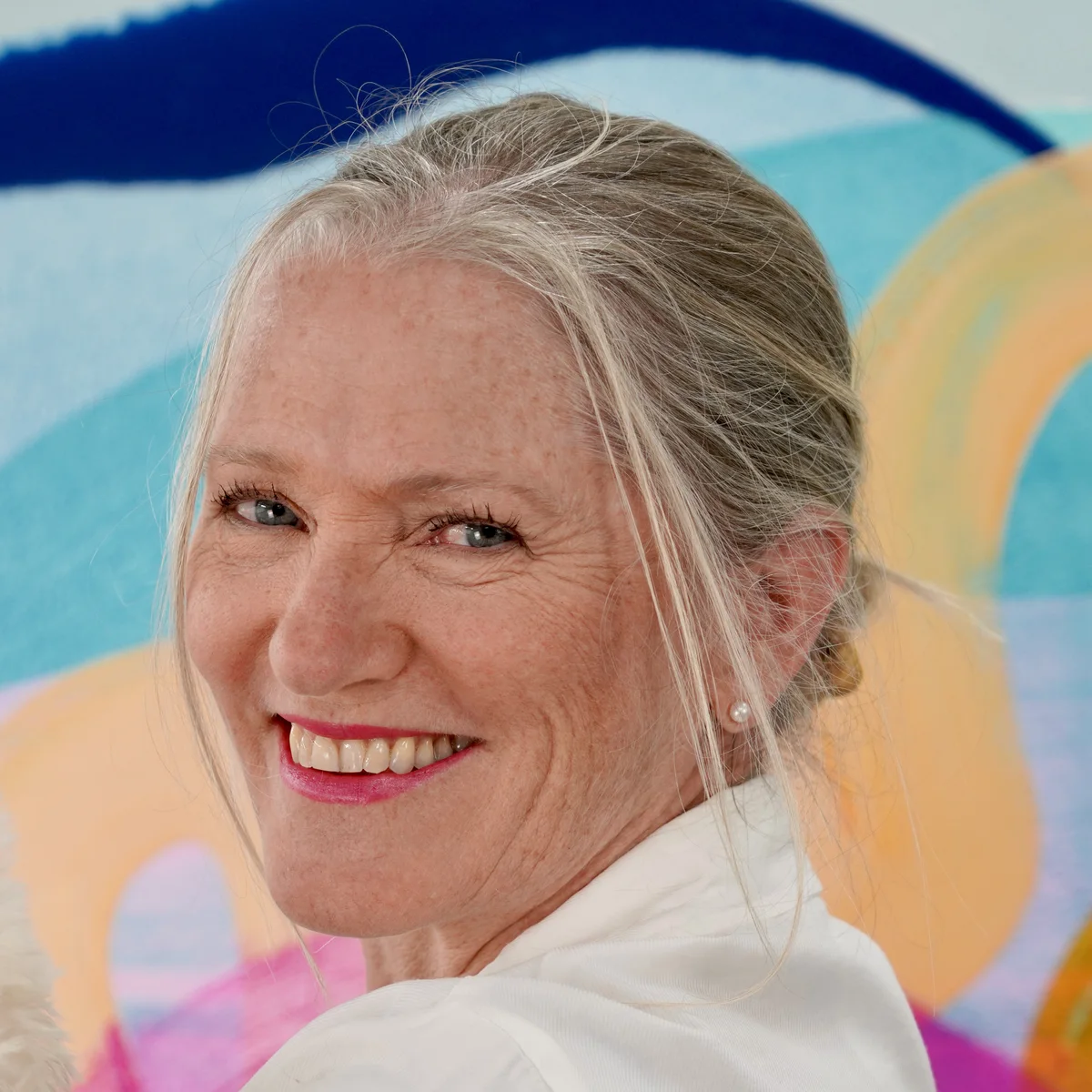 Claire Desjardins in front of one of her colourful abstract paintings.