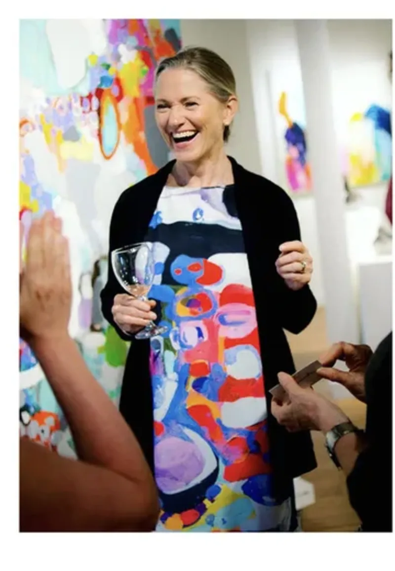 Claire Desjardins in a gallery with colourful artwork.