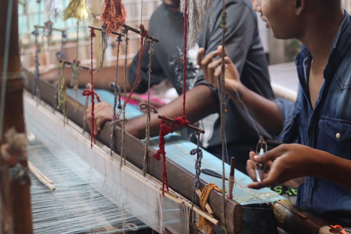 Two weavers working the fine warp of a jamdani handloom in Narayanganj, Bangladesh.