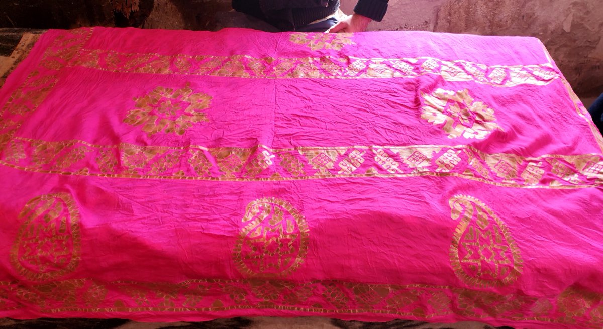 A pink silk kelaghayi mid-production in a Basqal workshop, its stamped gold patterns emerging.