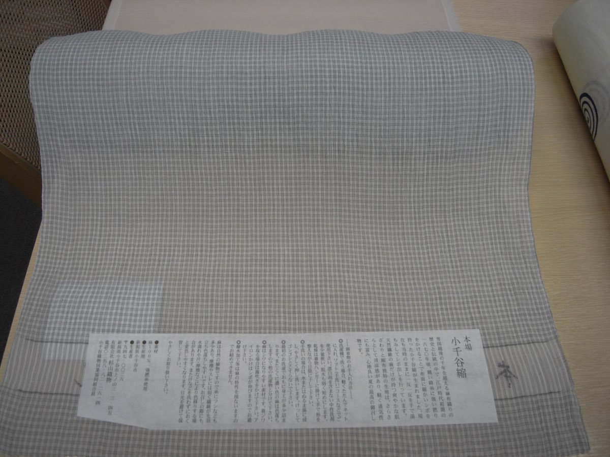 A bolt of Ojiya-chijimi ramie crepe with its paper certification label — the finished summer cloth.