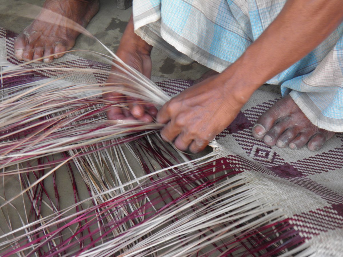 A weaver's hands working fine strips of murta cane into a shital pati mat in Sunamganj, greater Sylhet.