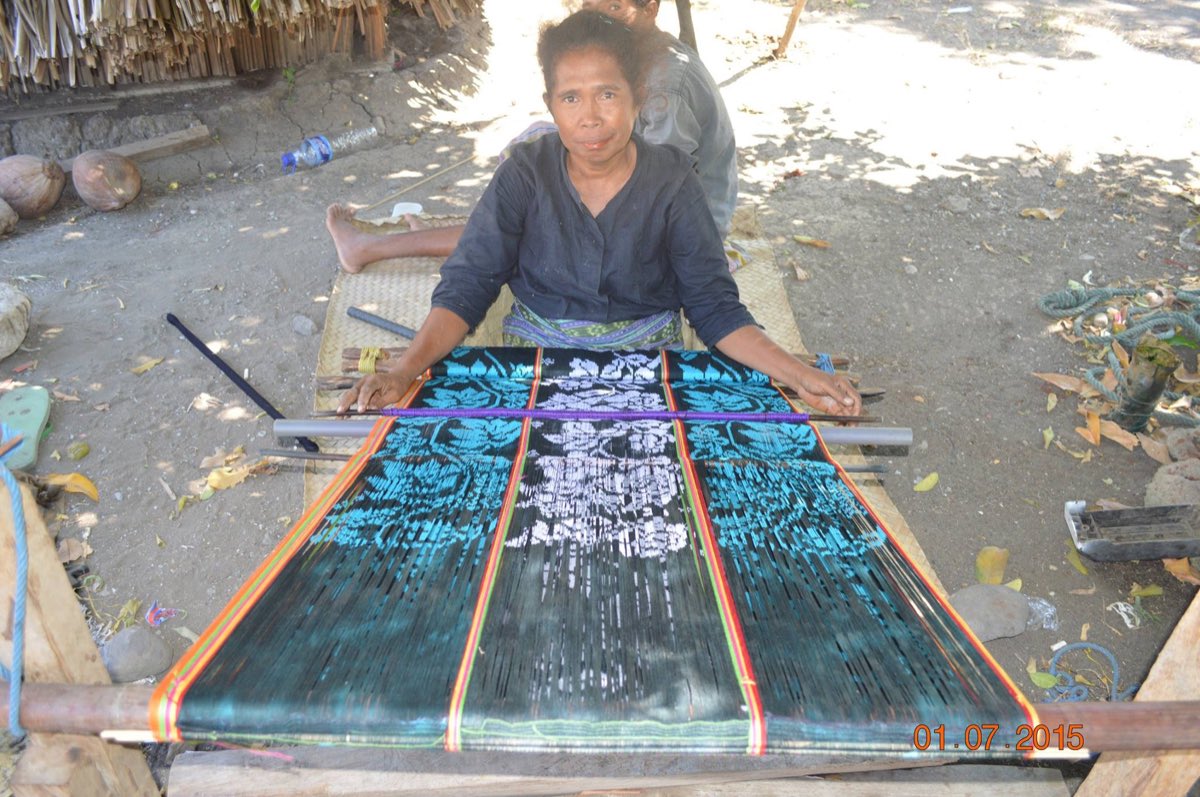 A weaver in Oecusse, Timor-Leste, working a tais on a backstrap loom.