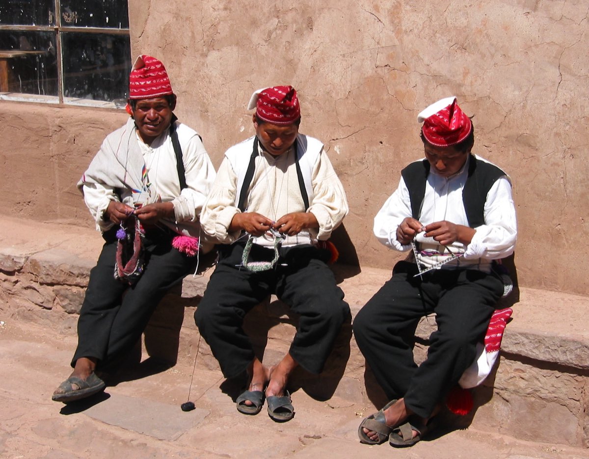 Taquile islanders knitting together on Lake Titicaca — on Taquile, the knitters are the men.